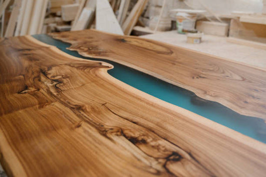 Wooden table with a blue resin river in a workshop setting