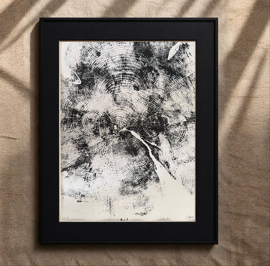 Framed black and white artwork on a wooden surface